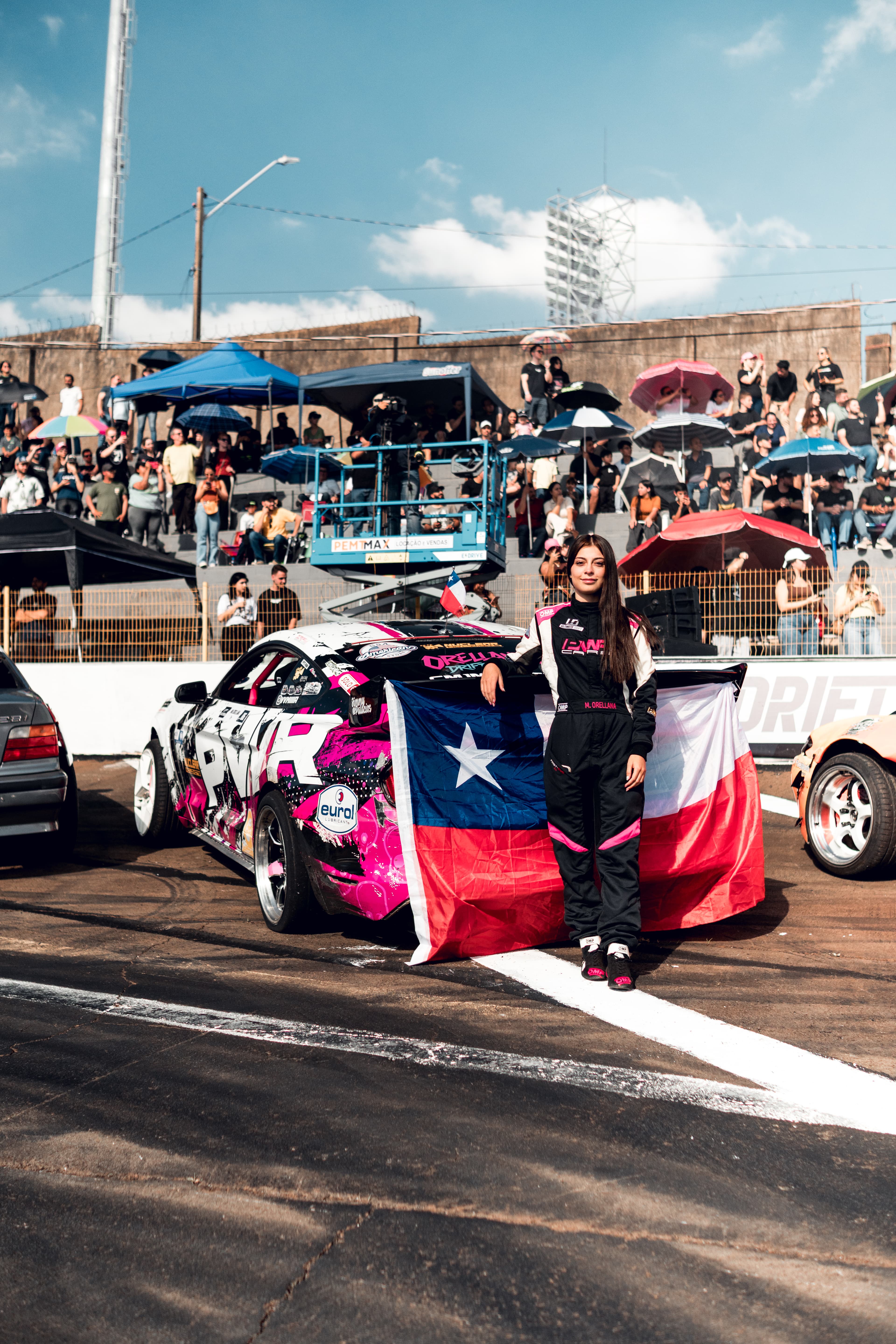 Mía Orellana posando junto a su auto