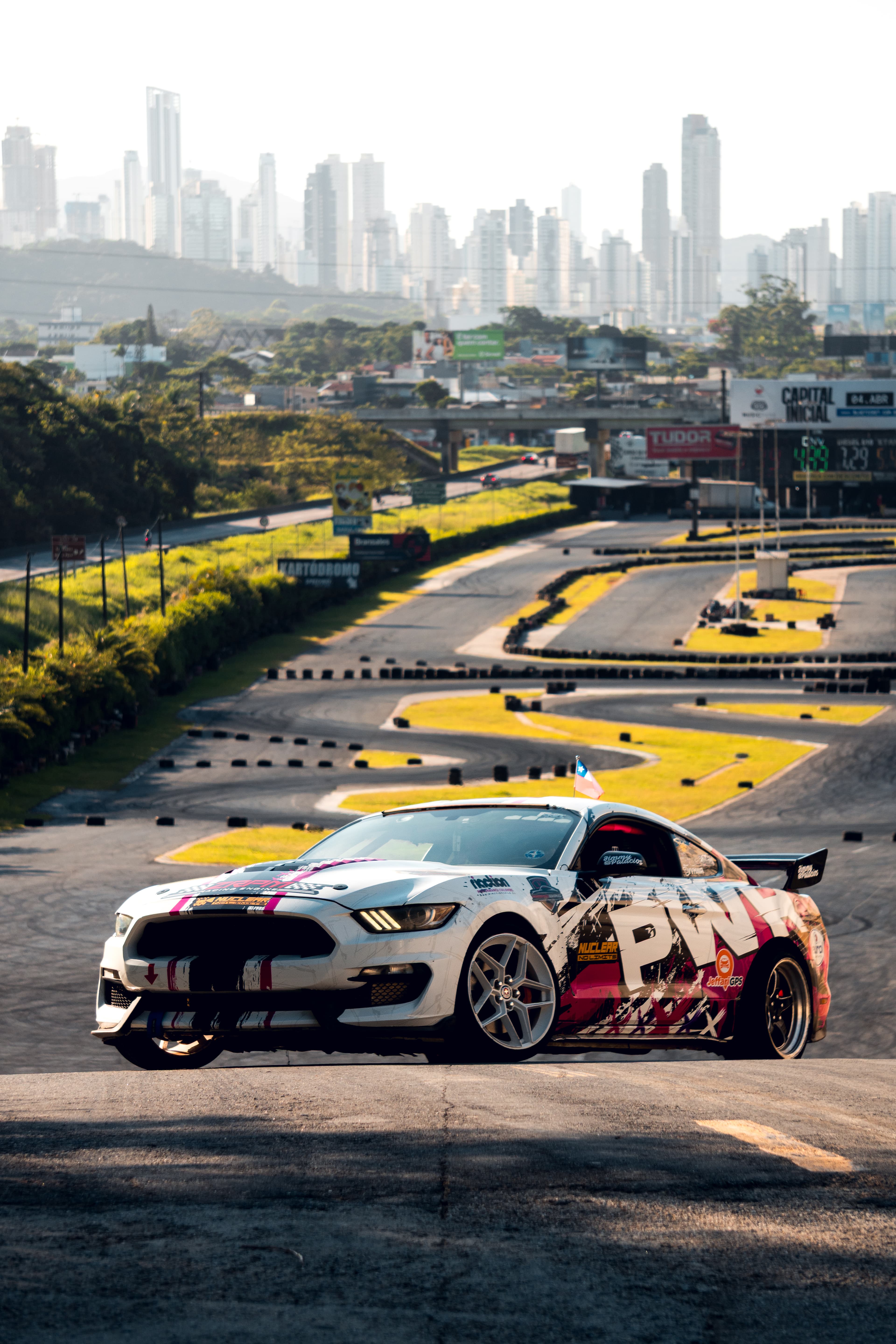 Mustang de drift con el horizonte de la ciudad de fondo